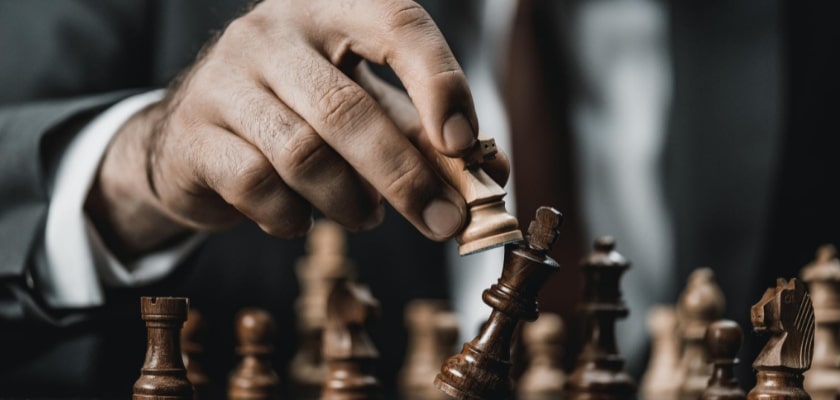 Vista da vicino di un uomo d’affari che tiene in mano la figura degli scacchi – Matched Betting