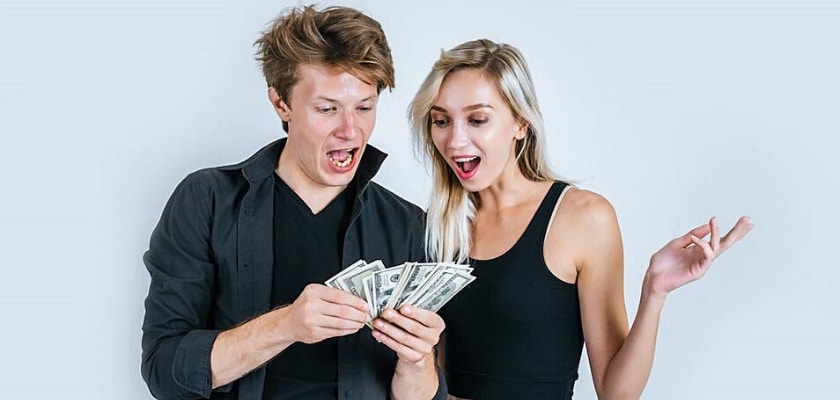 Primo piano di una coppia felice che osservano le banconote – Come fare soldi con le scommesse