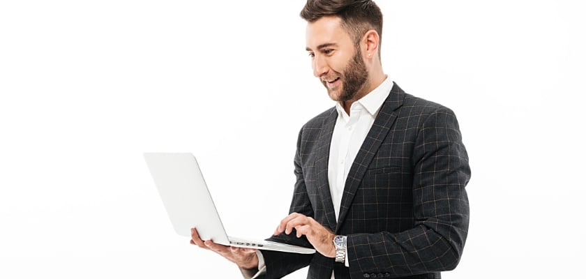 Ritratto di un uomo barbuto fiducioso che utilizza il computer portatile – Come fare soldi con le scommesse