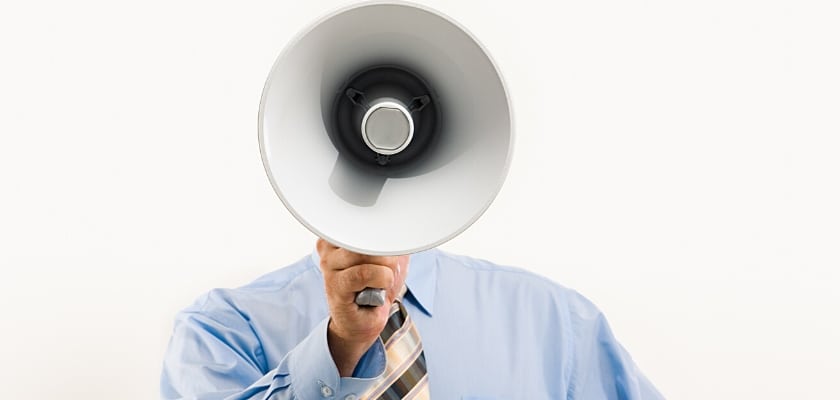Primo piano di un uomo che tiene un grande megafono rivolto verso la fotocamera – 10 strategie di marketing online